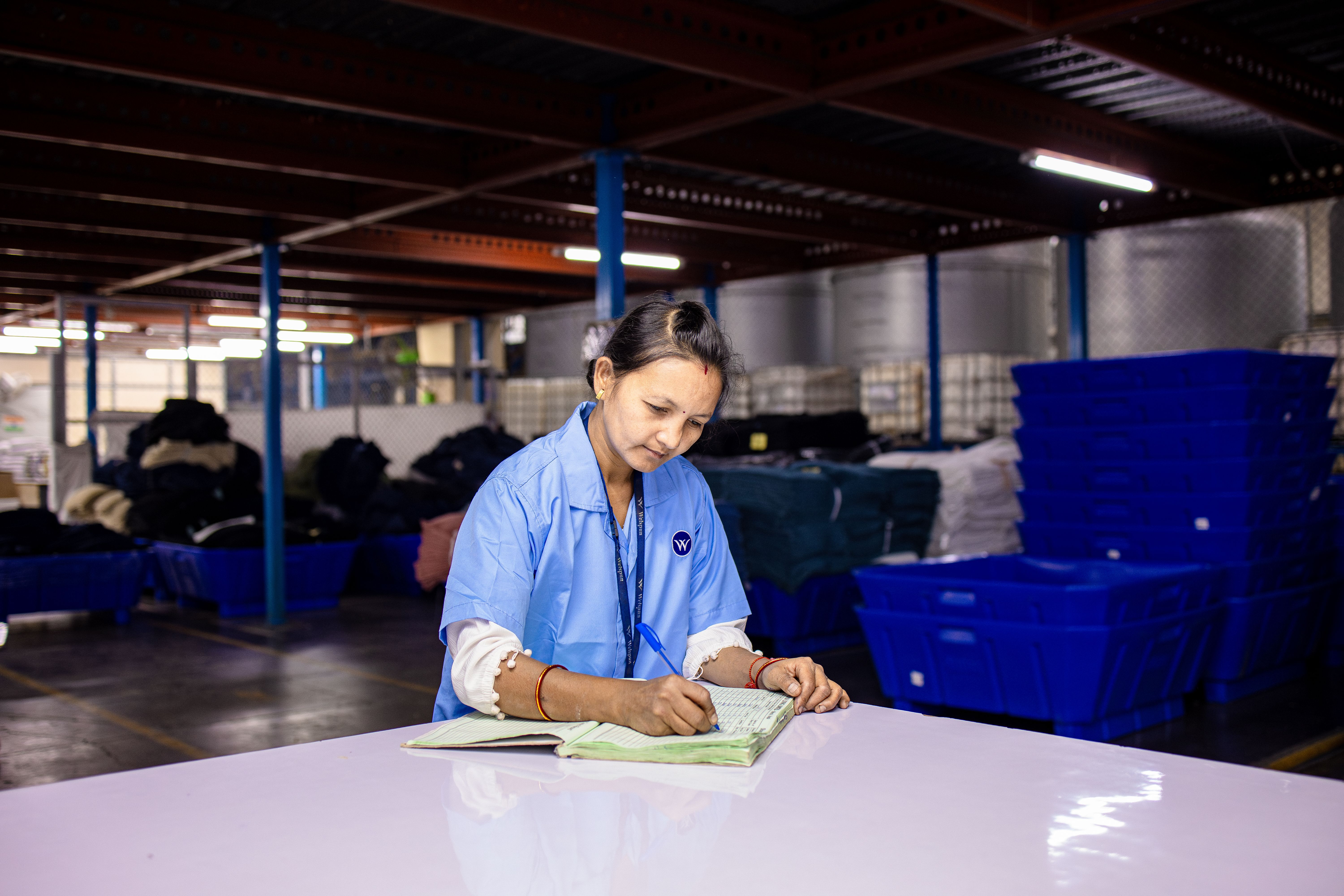 A worker filling in a paper logbook